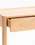 A close-up of the Wooden Stories Nell Console in Light Oak with Stone, featuring a partially open drawer, clean lines, and minimalist Scandinavian design against a plain white background.