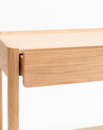 A detailed view of the Wooden Stories Nell Console in light oak with stone, showcasing its minimalist Scandinavian design, clean lines, and smooth surfaces, set against a white background.