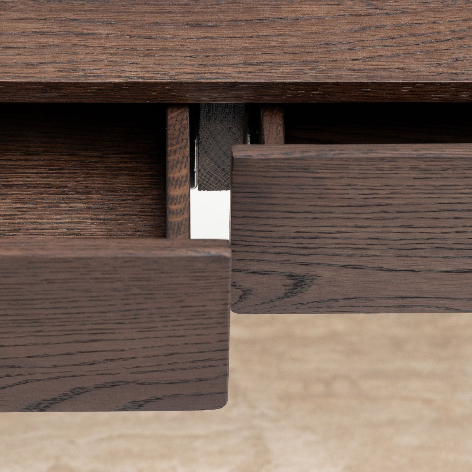Close-up of two partially open solid oak drawers on the Nell Console | Espresso Oak with Stone by Wooden Stories, highlighting visible wood grain and Scandinavian design elegance against a light background.