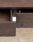 Close-up of two partially open solid oak drawers on the Nell Console | Espresso Oak with Stone by Wooden Stories, highlighting visible wood grain and Scandinavian design elegance against a light background.