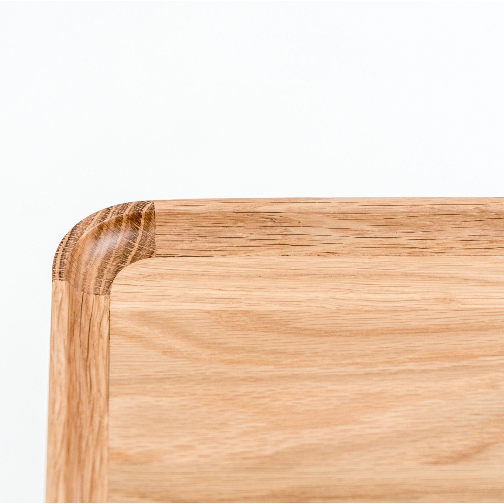 A close-up of the Nell Console by Wooden Stories in Light Oak with Stone reveals its smooth finish, rounded edges, and natural wood grain—an elegant, Scandinavian-inspired piece shown against a plain white background.