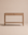 The Nell Console | Latte Oak by Wooden Stories, crafted from solid oak, features two drawers and a lower shelf. Set against a plain beige background, its simple, modern silhouette highlights the natural wood grain in classic Scandinavian design.