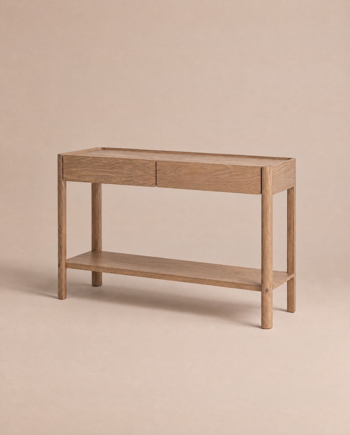 The Nell Console in Latte Oak by Wooden Stories is showcased against a plain beige background. Drawing inspiration from Scandinavian design, this solid oak table features two drawers, a lower shelf, and a minimalist silhouette with straight legs and natural wood grain texture.