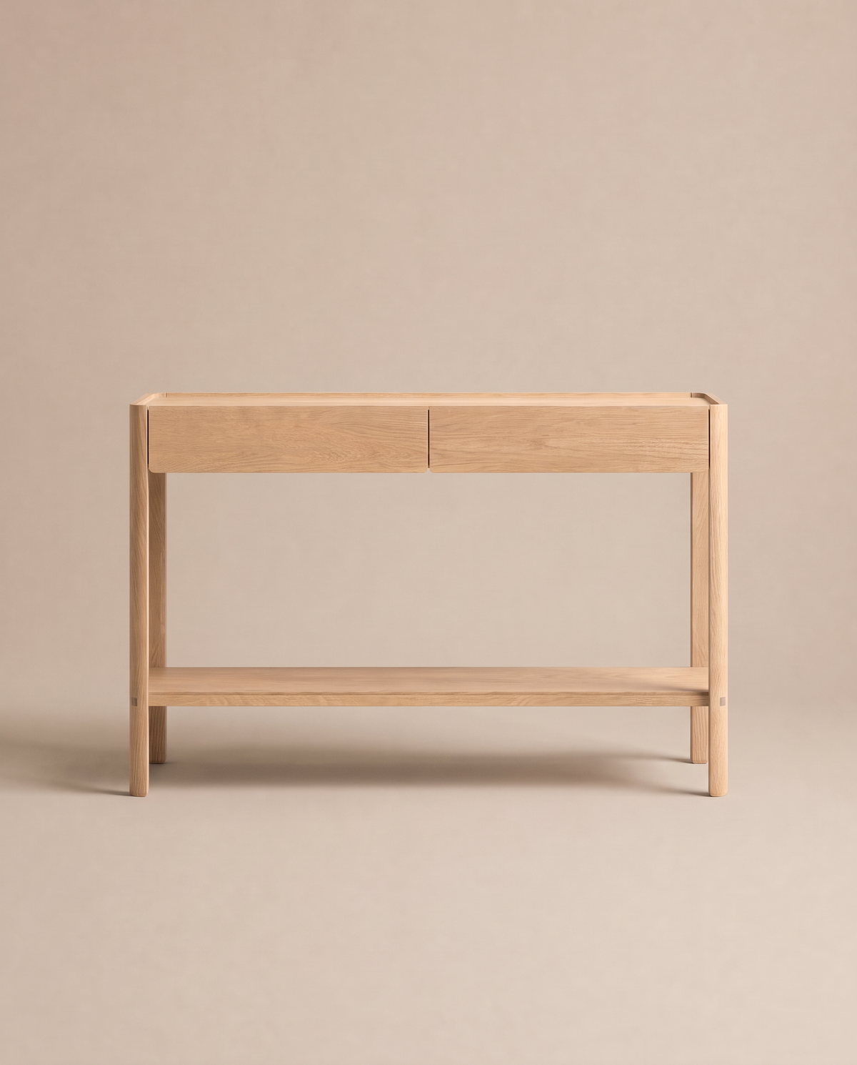 The Nell Console in Light Oak by Wooden Stories, featuring a minimalist Danish design with solid oak construction, two drawers, and an open lower shelf, is showcased against a plain beige background.