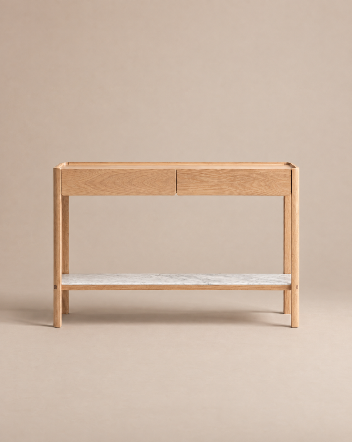 The Nell Console by Wooden Stories features solid light oak construction, two soft-close drawers, and a lower white stone shelf, showcased against a plain beige background.