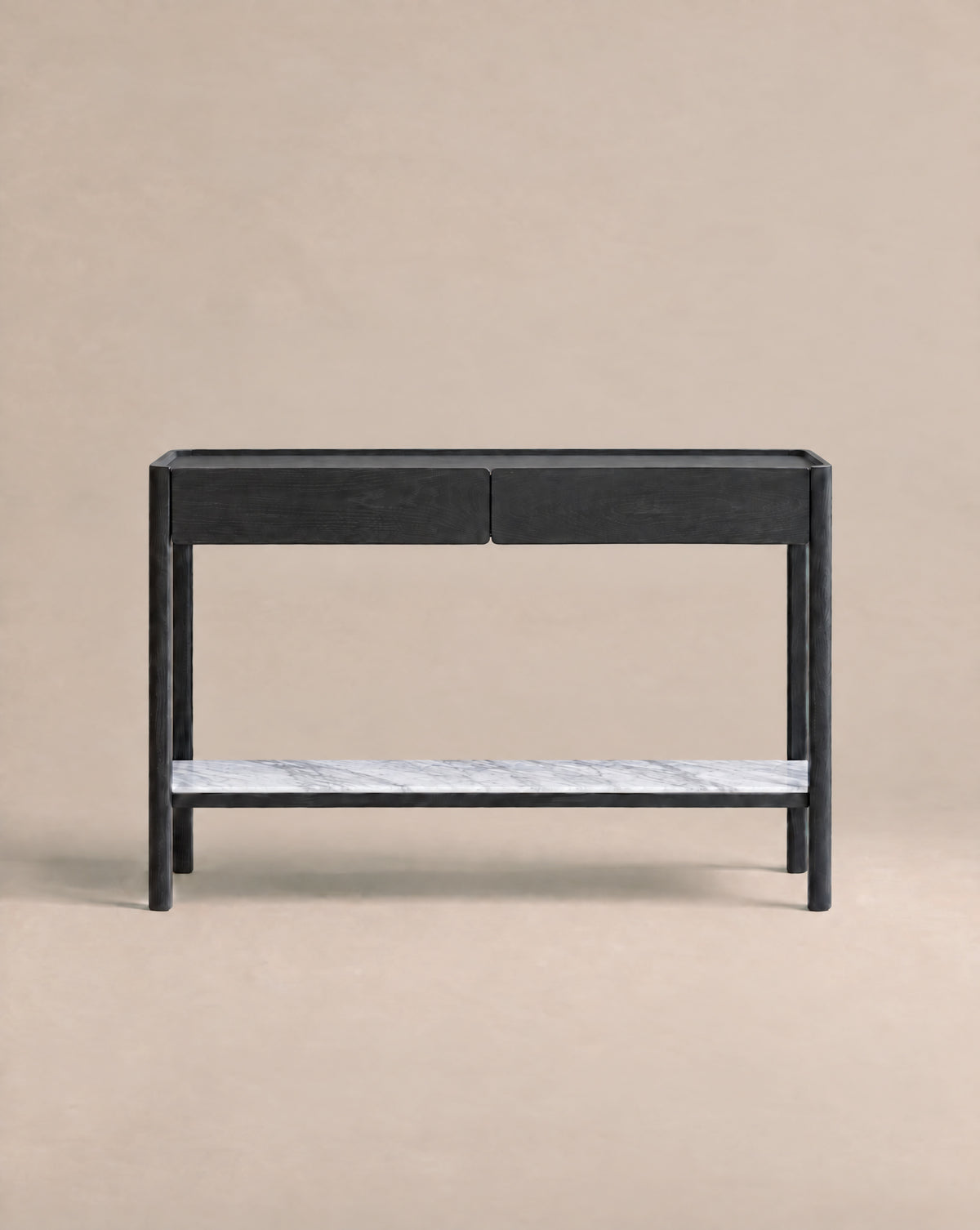 A minimalist black console table from Wooden Stories’ Danish collection, the Nell Console in Black Oak with Stone features two drawers and a white stone lower shelf. Set against a plain beige background, this piece embodies Scandinavian design principles with its refined simplicity and timeless appeal.