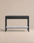 A minimalist black console table from Wooden Stories’ Danish collection, the Nell Console in Black Oak with Stone features two drawers and a white stone lower shelf. Set against a plain beige background, this piece embodies Scandinavian design principles with its refined simplicity and timeless appeal.
