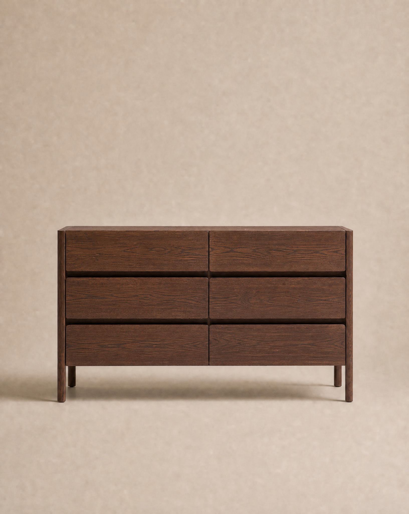 The Nell Wide Dresser by Wooden Stories, a dark wooden dresser featuring six drawers and exquisite timber joinery, is showcased against a plain beige background.