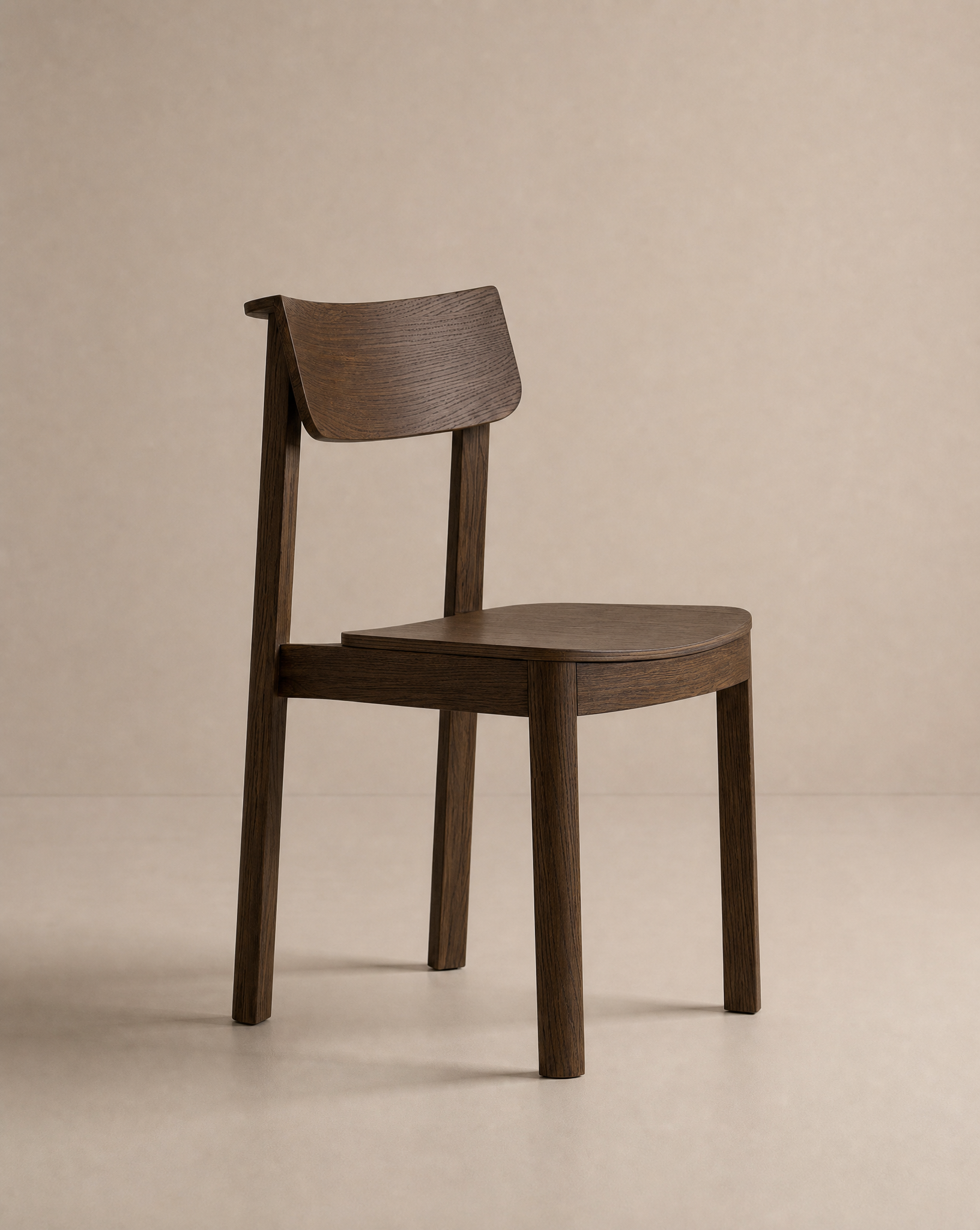 The Wooden Stories Noki Dining Chair | Wood is a minimalist solid wood chair with a curved backrest and seat, dark brown finish, and clean lines. Contract grade quality ensures lasting durability. Shown against a plain beige background.