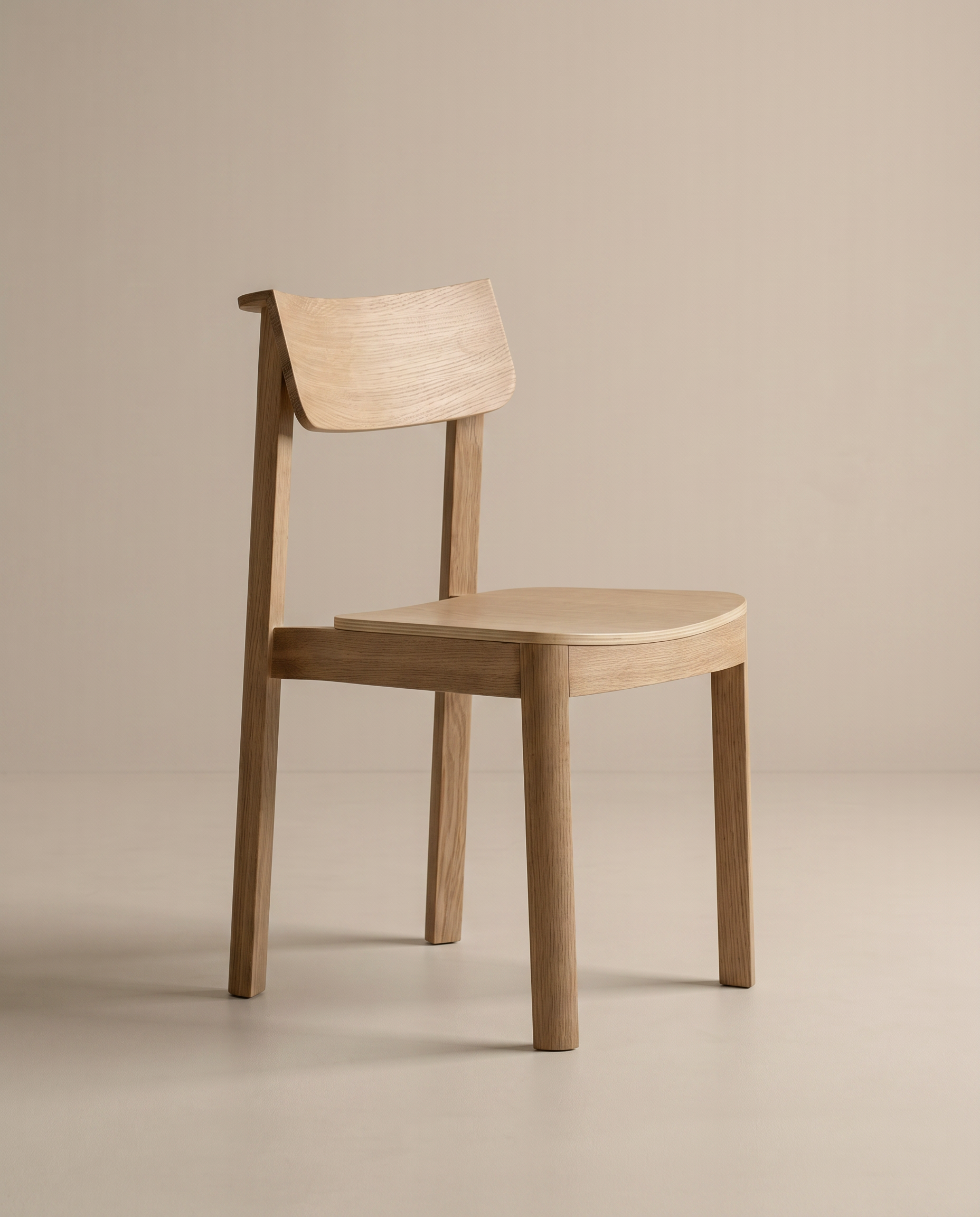 The Noki Dining Chair | Wood by Wooden Stories features a simple, modern design with a curved backrest and seat, clean lines, and a natural wood finish. This contract grade solid wood chair is set against a plain beige background.