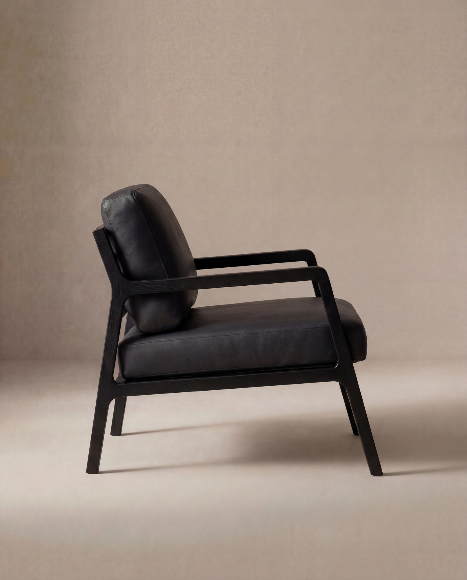 The Nysse Lounge Chair | Leather by Wooden Stories, featuring a solid oak frame with cushioned seat and backrest, is shown in side profile against a plain beige background.