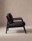 The Nysse Lounge Chair | Leather by Wooden Stories, featuring a solid oak frame with cushioned seat and backrest, is shown in side profile against a plain beige background.