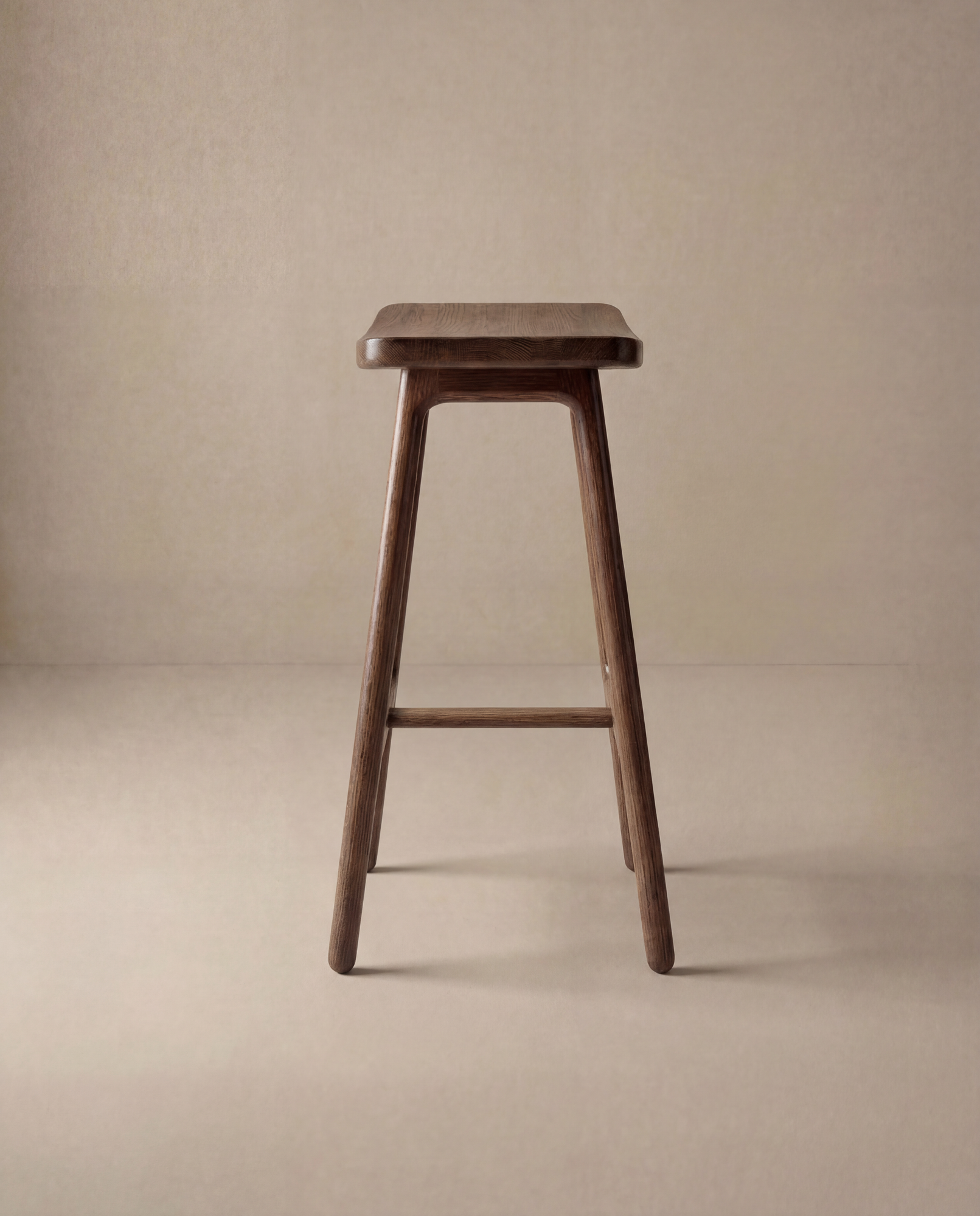 The Odd Counter Stool | Wood by Wooden Stories is a simple solid oak stool with four legs, a rectangular seat, and footrest, shown against a neutral beige background—timeless furniture for any space.