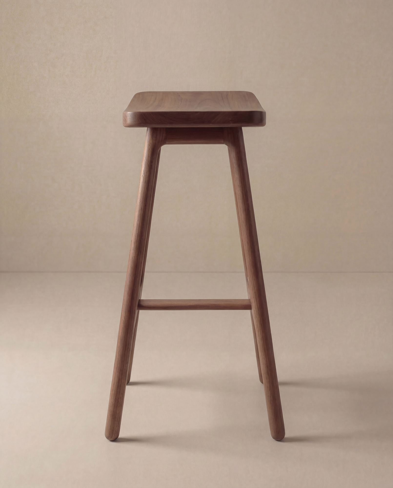 The Odd Counter Stool | Wood by Wooden Stories features a simple Danish design with four tapered legs and a rectangular solid oak seat, shown on a light floor against a beige background.