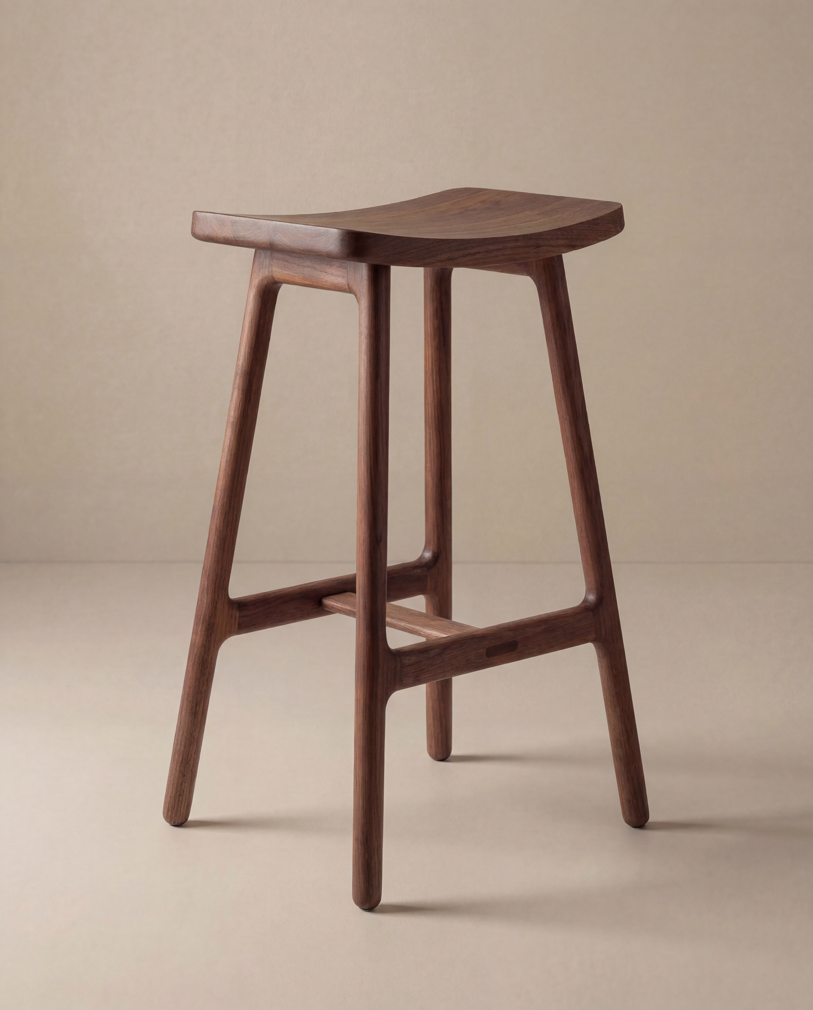 The Odd Counter Stool | Wood by Wooden Stories features a solid oak, Danish design with a curved seat and four angled legs joined by horizontal supports, shown against a plain beige background.