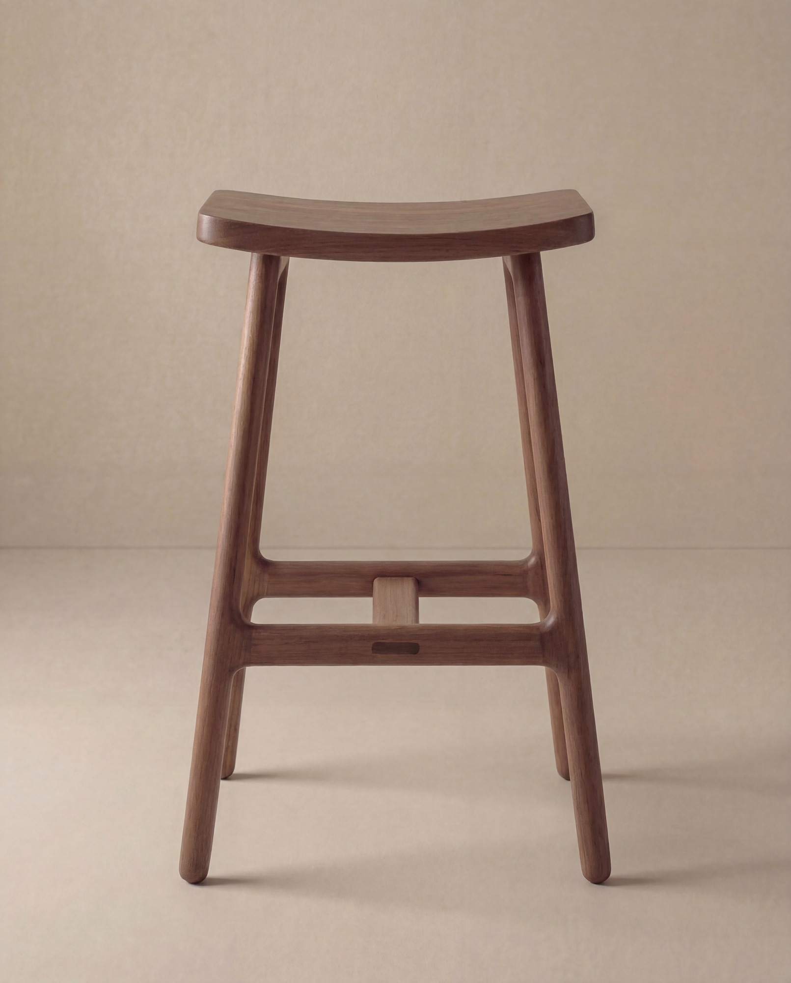 The Odd Counter Stool | Wood by Wooden Stories is a counter-height, solid oak stool with a curved seat, four legs, and smooth edges in a minimalist design, shown against a neutral beige background.