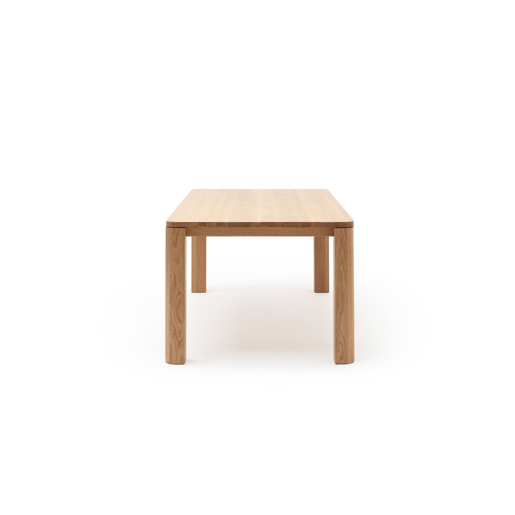 The Oli Dining Table by Wooden Stories is a minimalist piece from the Danish collection, crafted from solid American oak with four straight legs and a smooth rectangular surface, shown photographed end-on against a plain white background.