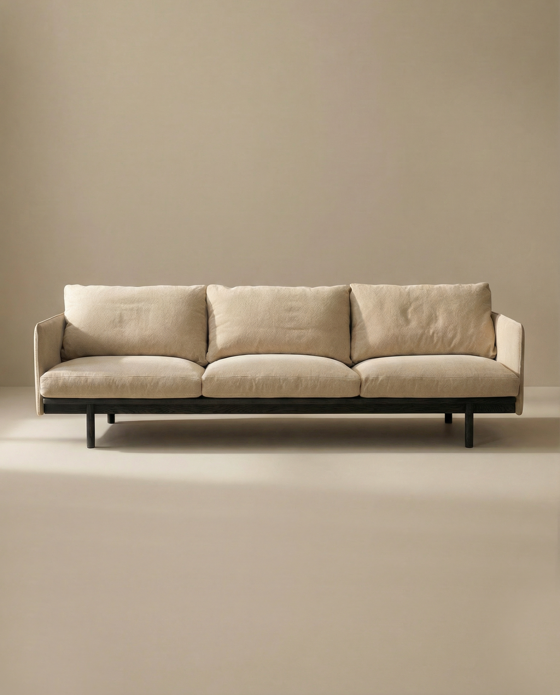 The Pensive Sofa | Fabric by Wooden Stories, a modern minimalist Danish design with three seat cushions and black legs, is set against a plain beige background.