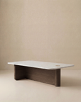 The Pivot Coffee Table | Rectangular - Wood & Stone by Wooden Stories features a white marble top, solid oak base, clean lines, and a unique corner cut-out—all set against a plain beige background.