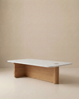 The Pivot Coffee Table | Rectangular - Wood & Stone by Wooden Stories features a solid oak base and a white marble top, displayed against a plain beige background. From the Danish Collection.