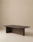 The Wooden Stories Pivot Coffee Table | Rectangular features a modern, minimalist design with a smooth dark brown finish, rounded edges, and a sturdy solid oak base, shown here against a plain beige background.