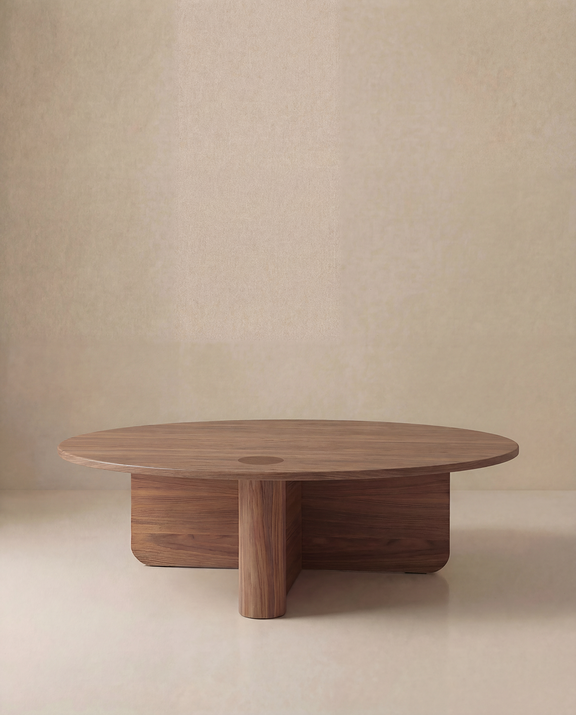 The Pivot Coffee Table | Round by Wooden Stories features a large, smooth solid wood top and thick intersecting cylindrical legs, shown against a plain beige background.