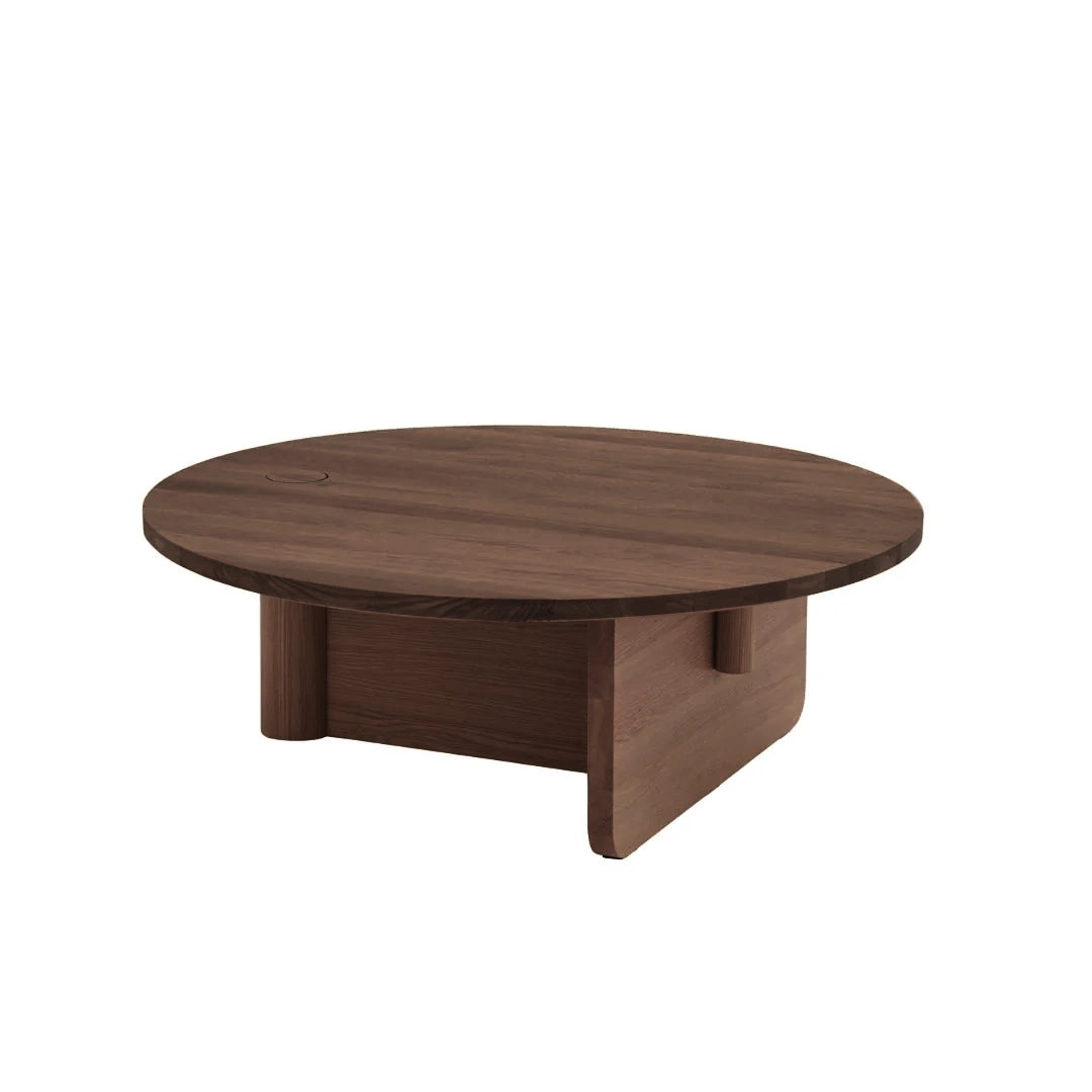 The Pivot Coffee Table | Round - Wood by Wooden Stories features a solid wood build, smooth flat top, intersecting panel legs, and a rich walnut finish.