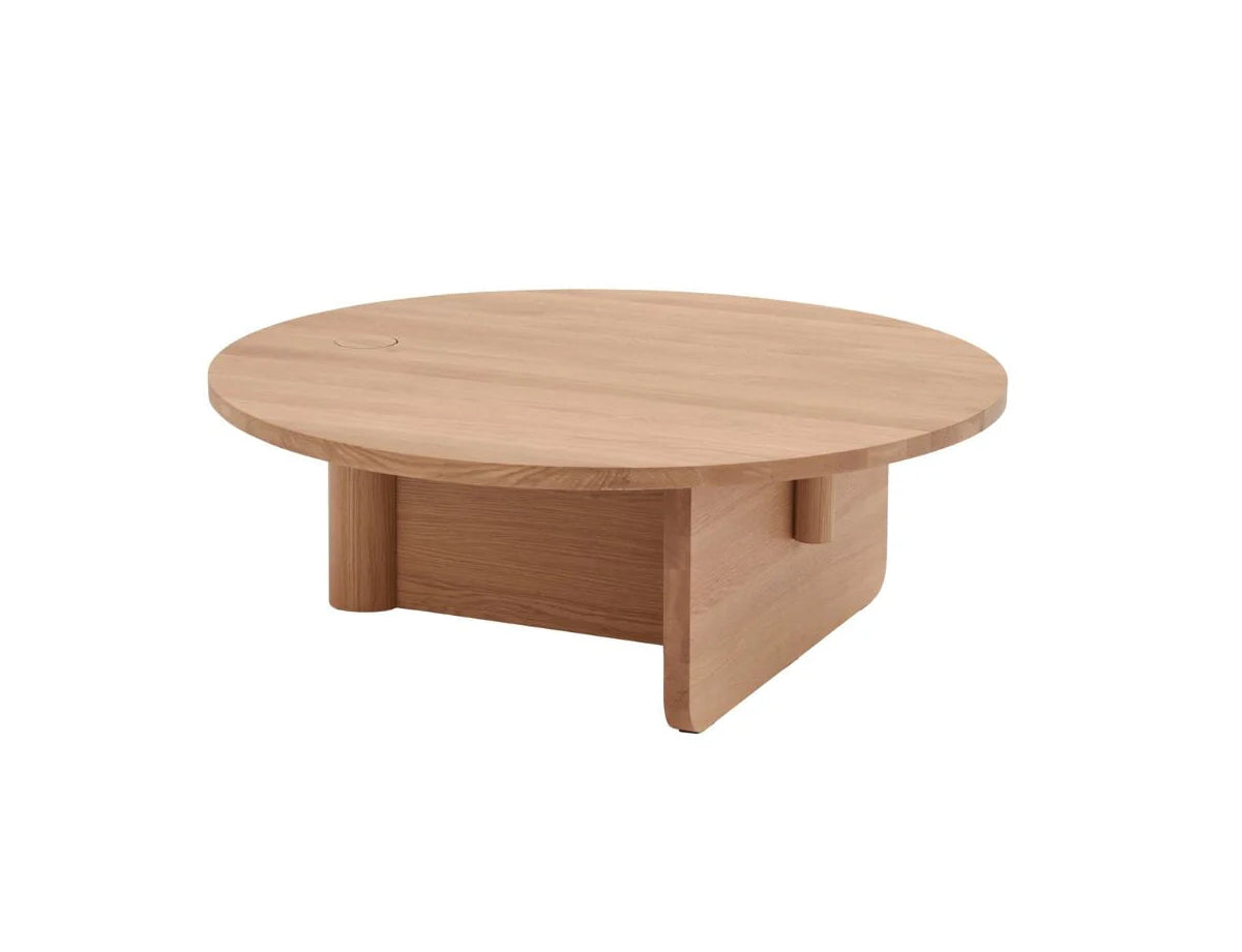 The Pivot Coffee Table | Round - Wood by Wooden Stories features a solid wood build, smooth light finish, and minimalist design with thick top and intersecting panel legs—making it a modern centerpiece for any living area.