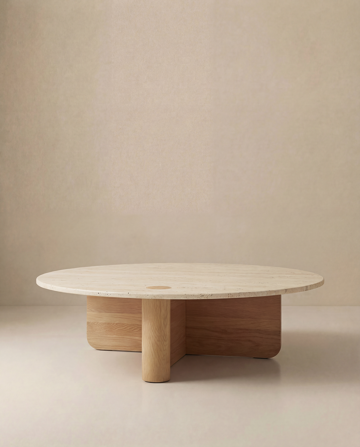 The Pivot Coffee Table | Round - Wood &amp; Stone by Wooden Stories features a smooth light stone top and geometric solid oak base, offering a modern minimalist look inspired by the Danish Collection against a neutral beige background.