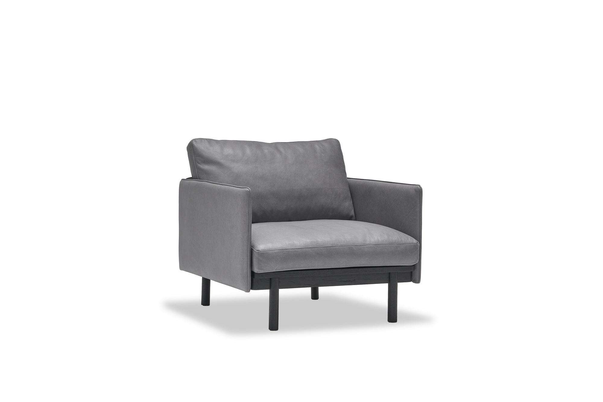 A modern gray Pensive Lounge Chair in leather by Wooden Stories, with Danish lines, slim black legs, cushioned seat and backrest, shown against a plain white background.