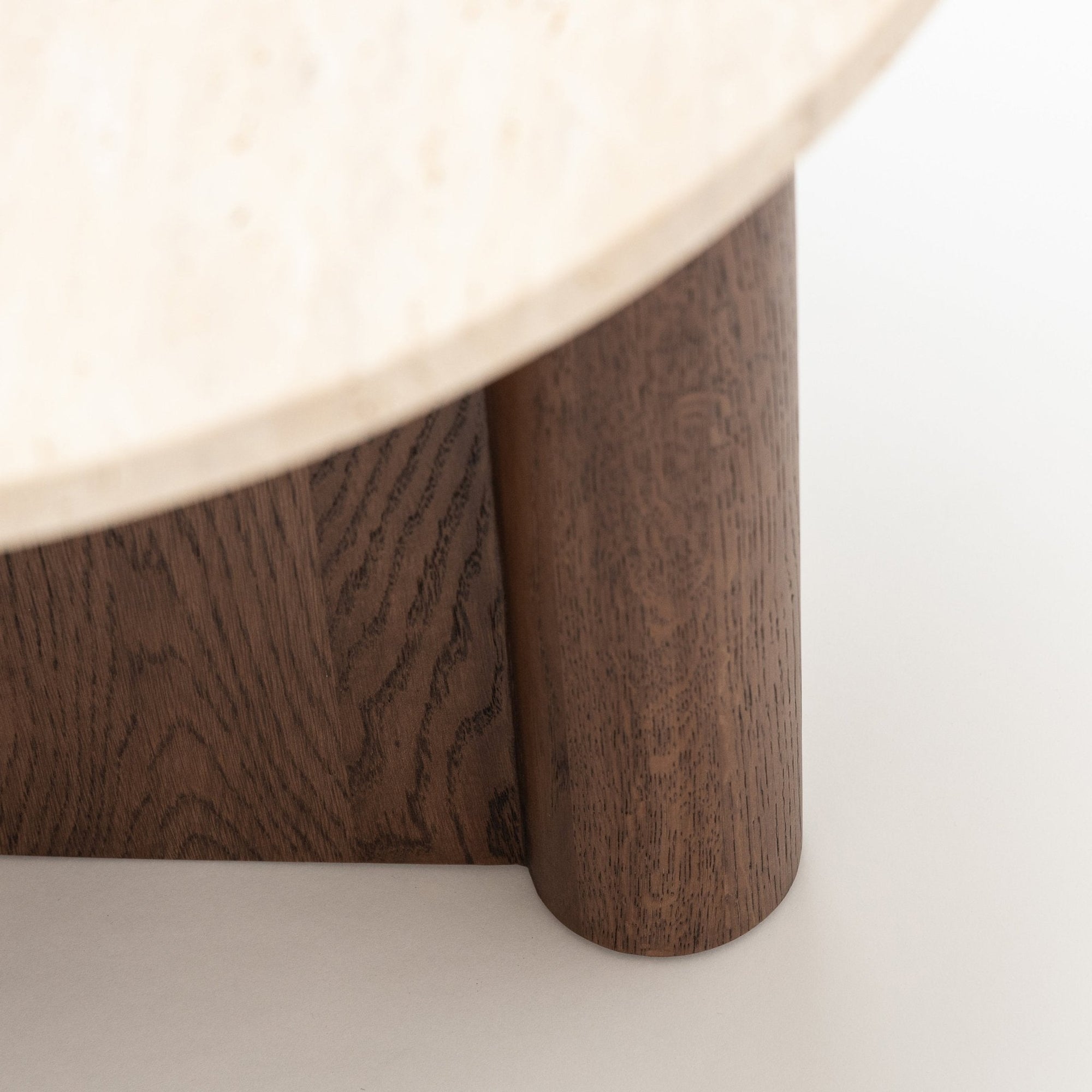 Close-up of the Wooden Stories Pivot Side Table | Espresso Oak - Stone Top, featuring a light honed stone round top and dark espresso oak cylindrical legs, highlighting the striking contrast in materials and textures.