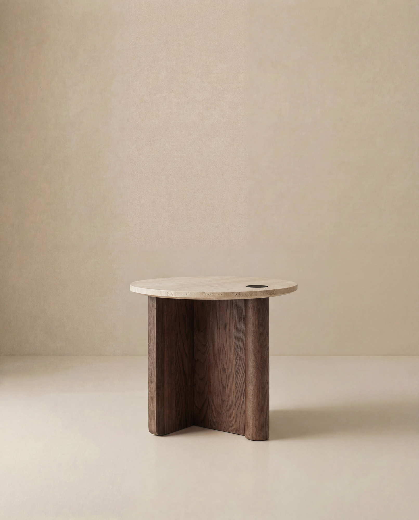 The Pivot Side Table | Wood &amp; Stone by Wooden Stories features a small, round light solid oak top with three dark wood legs. Its minimalist, modern Danish design stands out against a neutral beige background.