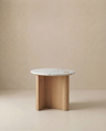 The Wooden Stories Pivot Side Table | Wood & Stone features a white marble top and three intersecting solid oak legs, shown against a plain beige background.
