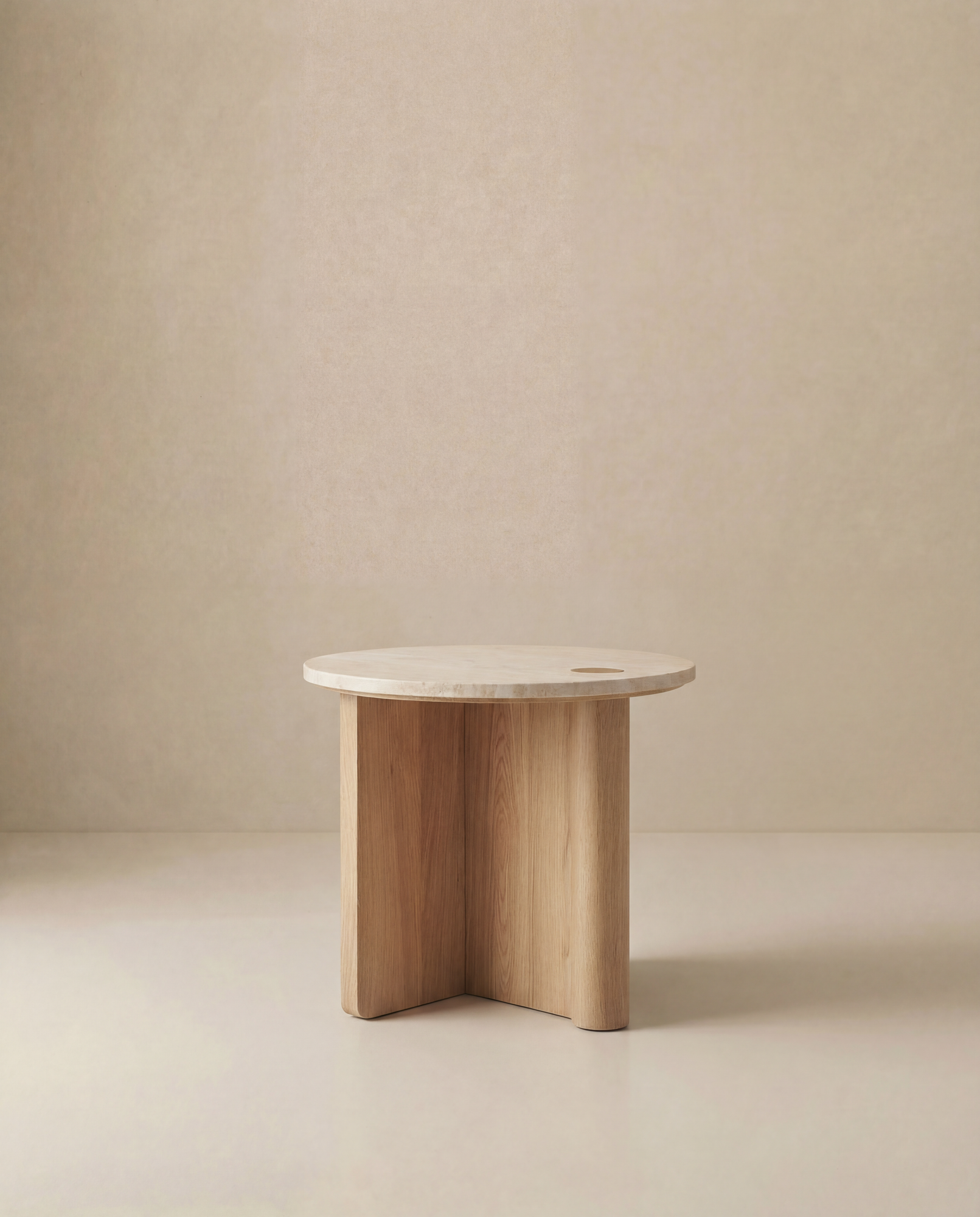 The Pivot Side Table | Wood &amp; Stone by Wooden Stories, with a solid oak round top and three curved legs, from the Danish Collection, is shown against a plain beige background.