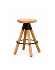 The Blix Counter Stool by SOBU features a round solid American ash seat, four angled legs with black metal brackets, and a circular black footrest. Set against a plain white background.