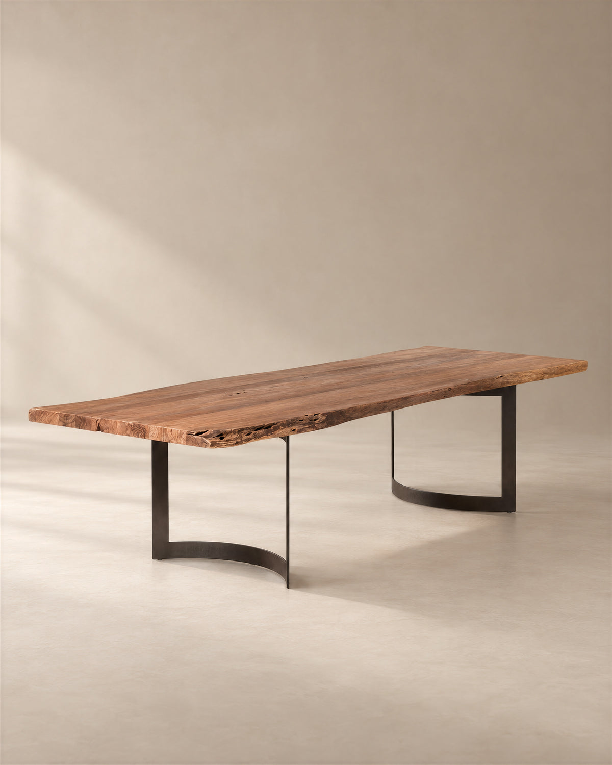 A SOBU Leviathan Live Edge Dining Table - Curved Metal Legs featuring a rectangular live-edge acacia wood top set upon two curved black metal legs.