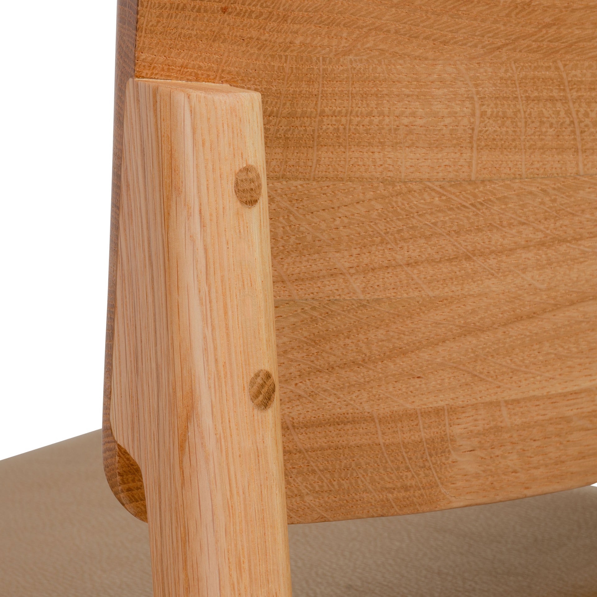 Close-up of the Poise Dining Chair | Light Oak by Wooden Stories, showing the backrest and rear leg with smooth, light oak wood grain, Danish-inspired lines, and round wooden dowel joints.