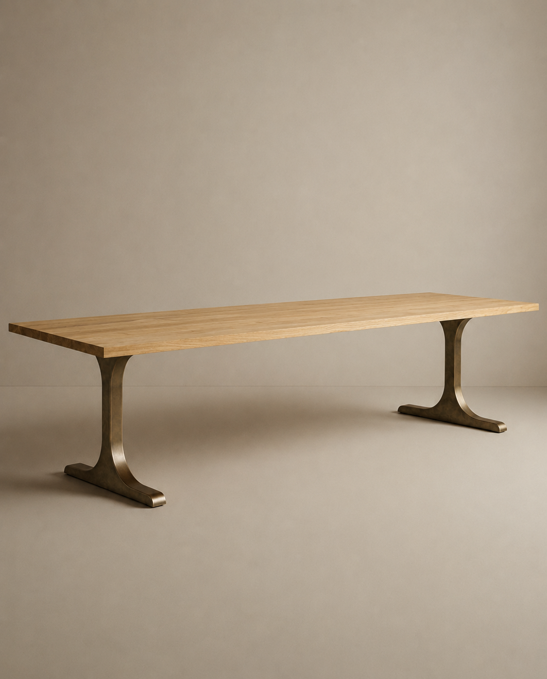 A long, rectangular Tommaso Dining Table by SOBU, crafted from European oak with a smooth surface and supported by two brass T-shaped metal pedestal legs, is set against a plain beige background.