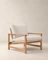 The Troubadour Lounge Chair | Fabric by Wooden Stories features a light wood frame and beige upholstered seat and back cushions, shown against a plain, neutral background.