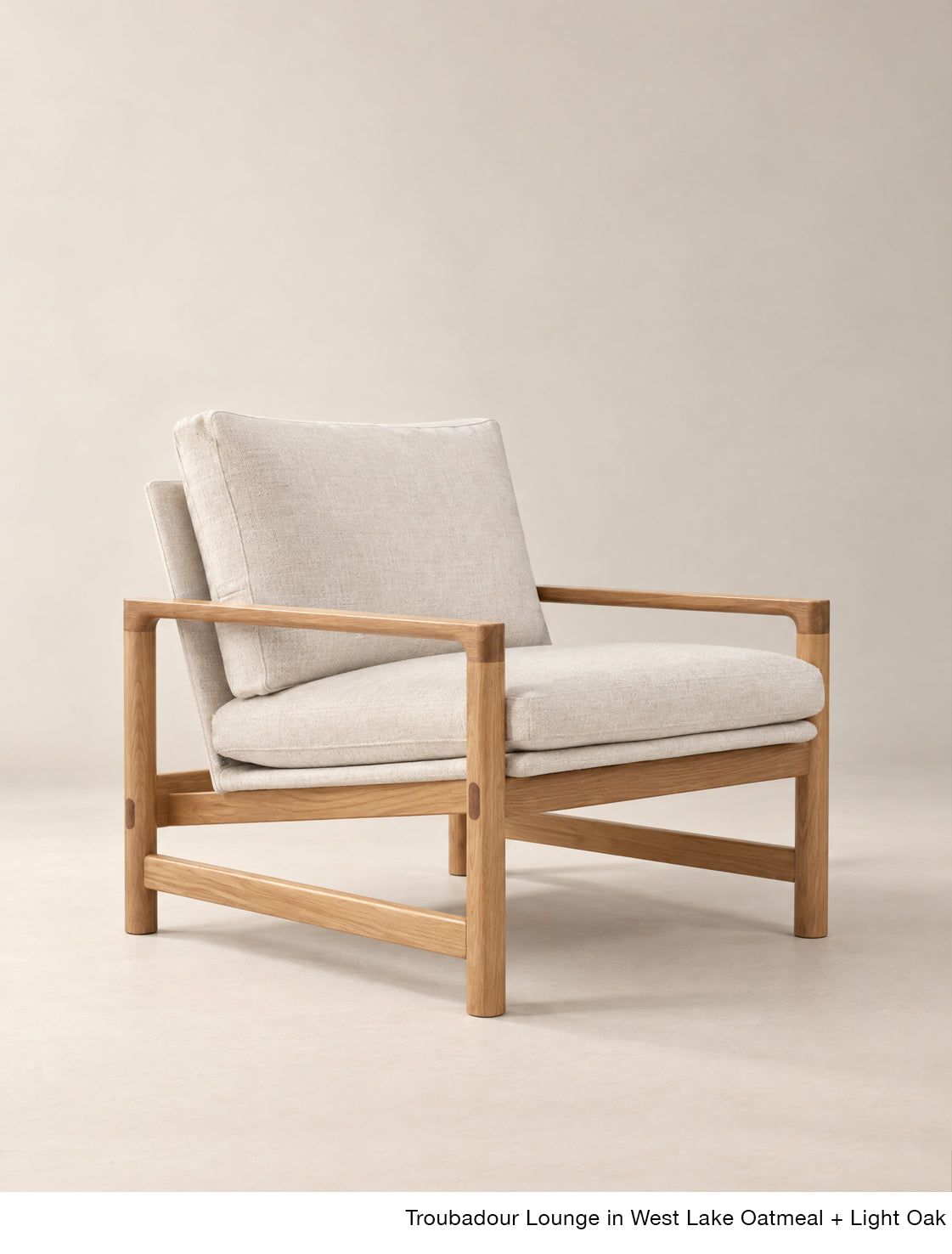 The Troubadour Lounge Chair | Fabric by Wooden Stories features a light oak frame and oatmeal cushions, offering a modern twist on mid-century style in the timeless Danish collection.