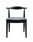 The SOBU Copenhagen Dining Chair – Black Ash is a modern, minimalist solid wood chair with a curved backrest and leather padded seat, shown against a plain white background.