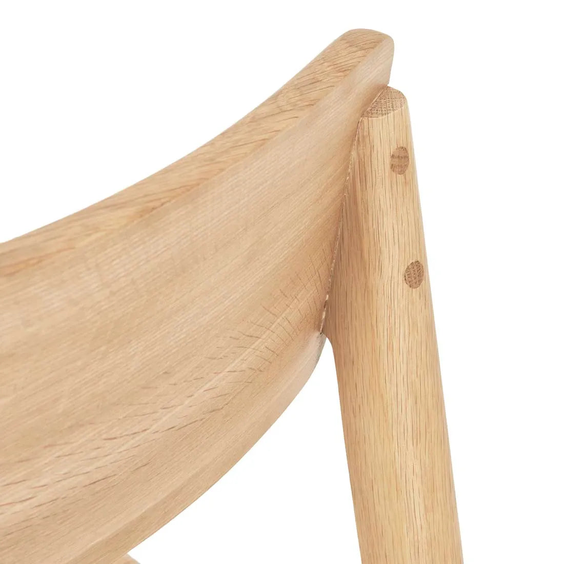 Close-up of the upper backrest and support of the Wooden Stories Poise Dining Chair in Light Oak, showcasing smooth natural wood grain and round joinery details.