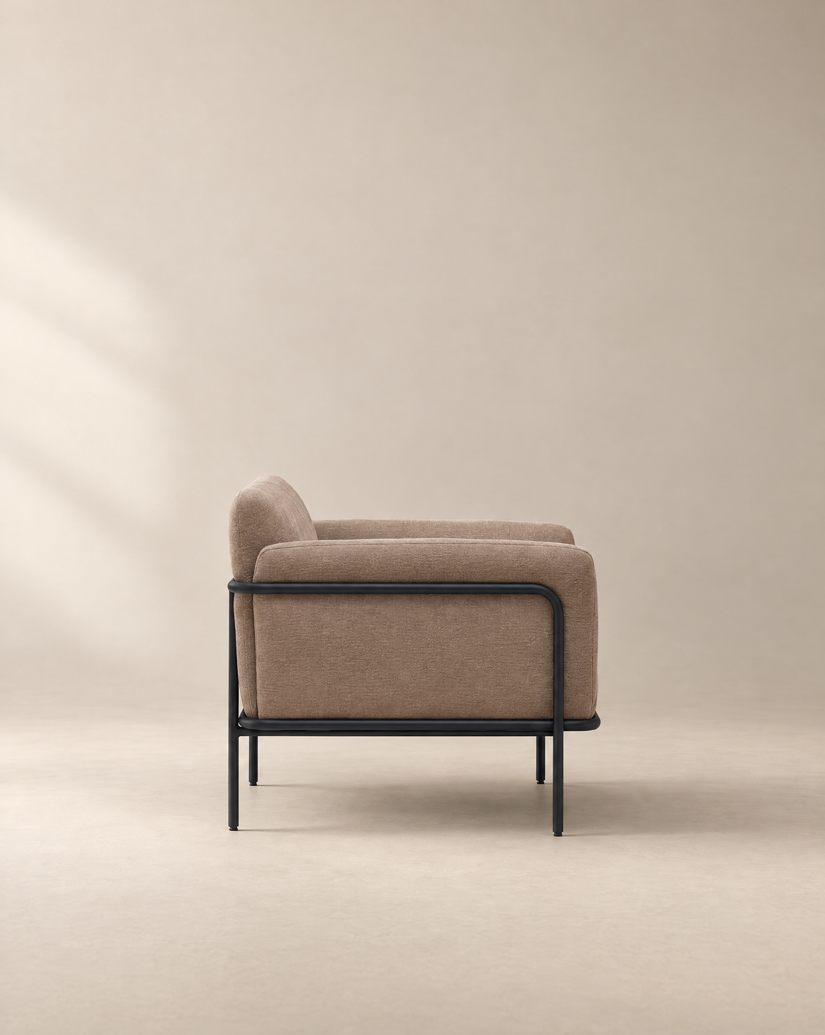 Profile view of a Scribe Lounge Chair | Fabric, a Bauhaus-inspired upholstered lounge chair with a dark metal frame.