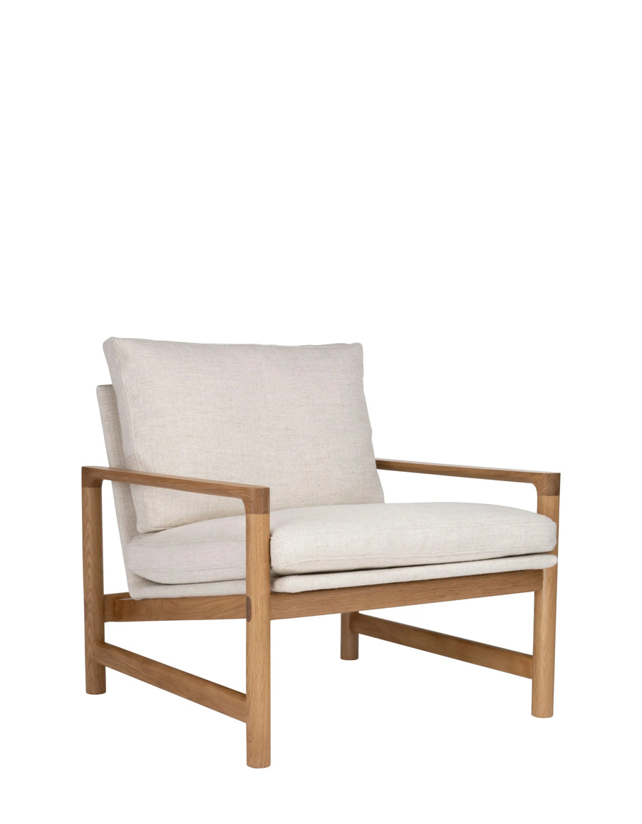 The Troubadour Lounge Chair | Fabric by Wooden Stories features a modern mid-century design with a light wood frame and off-white cushioned seat and backrest, displayed against a plain white background.