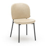 The Solace Dining Chair | Leather by Wooden Stories features a modern upholstered beige seat, rounded backrest, and four slim black metal legs, displayed against a white background.