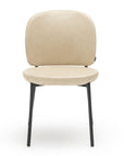 The Solace Dining Chair | Leather by Wooden Stories is a tan leather dining chair with a rounded backrest and seat, supported by four slender black metal legs. Its modern, minimalist style stands out against a white background.