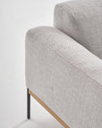 Close-up of the Wooden Stories Department Sofa 93" in light gray fabric, featuring Danish lines, a solid wood plinth base, and slim black metal legs, shown against a white background.