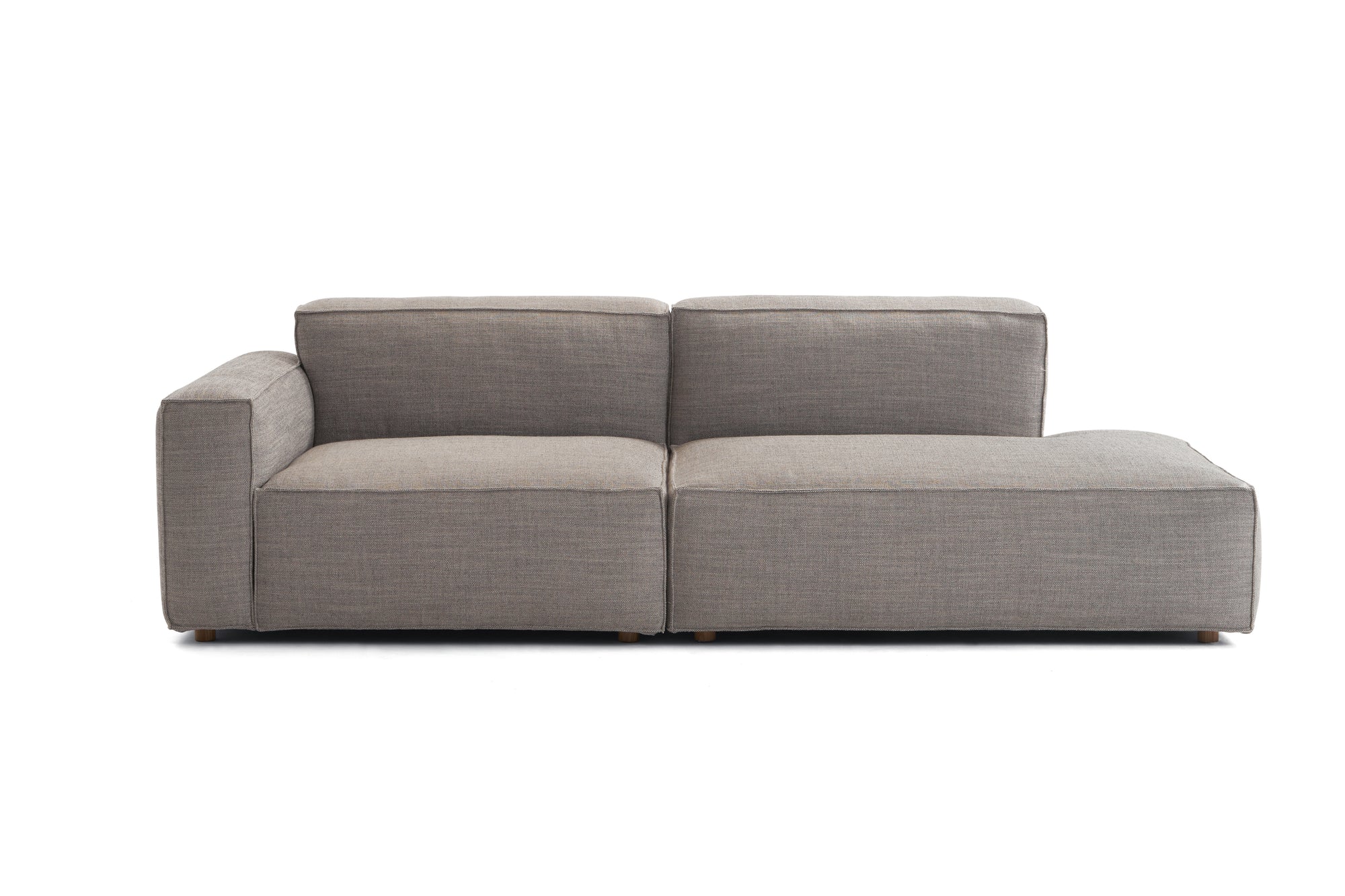 The Baker Modular Sofa | Fabric • M1 by Wooden Stories features a modern, light gray design with low, wide cushions and a left-side armrest, shown against a plain white background.