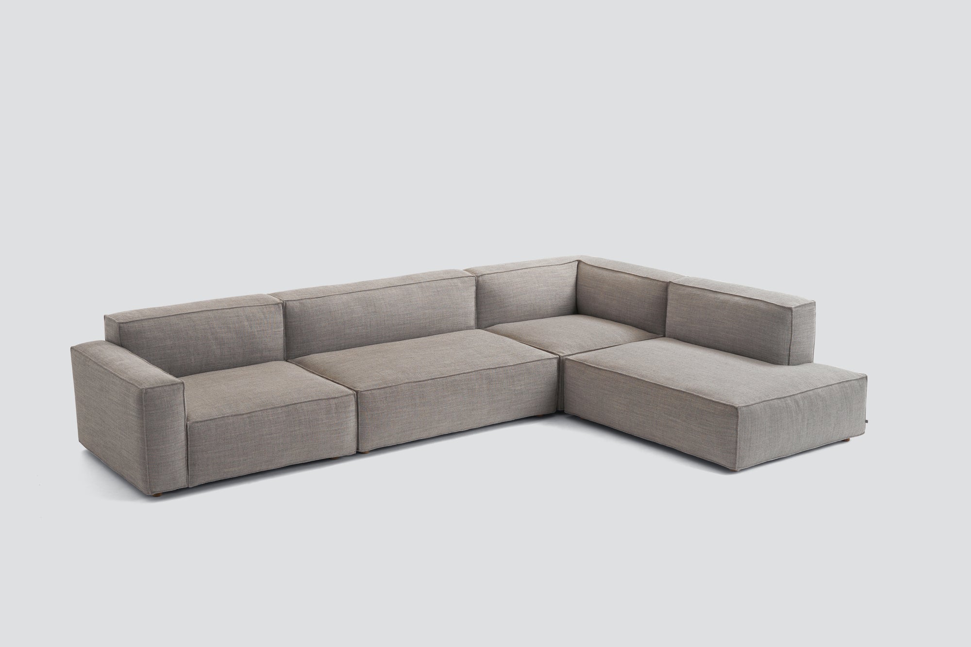 The Baker Modular Sofa | Fabric • M8 by Wooden Stories is a modern, L-shaped sectional in light gray fabric with clean lines and a minimalist design, shown here against a plain white background.
