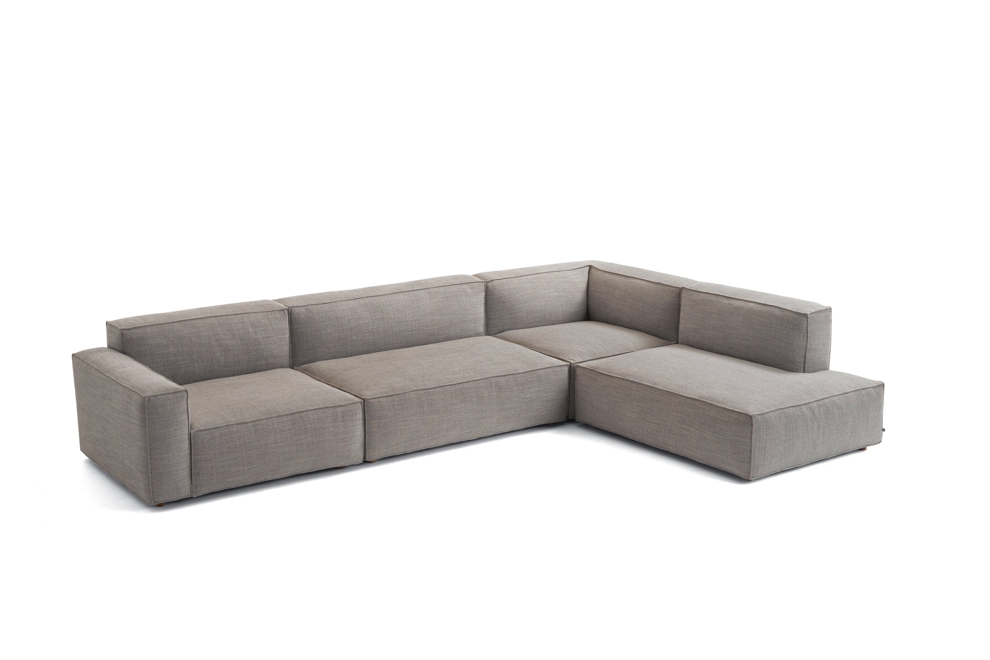 The Baker Modular Sofa | Fabric • M8 by Wooden Stories is a modern, modular L-shaped gray fabric sofa featuring Danish design, wide armrests, and low backrests, shown on a white background.
